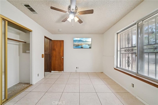 14676 Poplar St, Hesperia, CA 92345 - unfurnished bedroom with a textured ceiling, light tile patterned flooring, a closet, and a ceiling fan