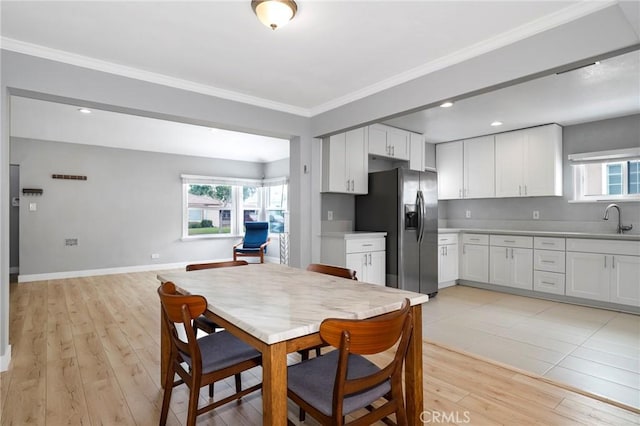 2804 W 84th St, Inglewood, CA 90305 - kitchen featuring stainless steel fridge with ice dispenser, light wood-style flooring, white cabinetry, a sink, and light countertops