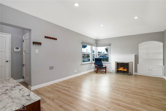 2804 W 84th St, Inglewood, CA 90305 - living room with light wood finished floors, recessed lighting, a brick fireplace, and baseboards