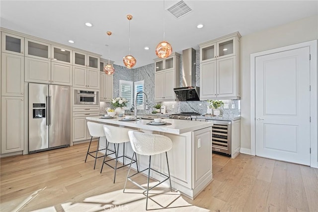 26290 Paseo Sillin, San Juan Capistrano, CA 92675 - kitchen featuring high end fridge, wall chimney exhaust hood, beverage cooler, a center island with sink, and light countertops