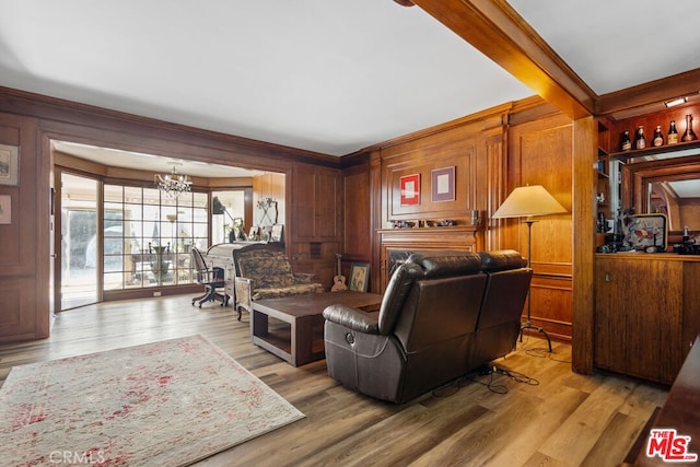 728 S Windsor Blvd, Los Angeles, CA 90005 - living room with a chandelier, ornamental molding, wooden walls, and wood finished floors