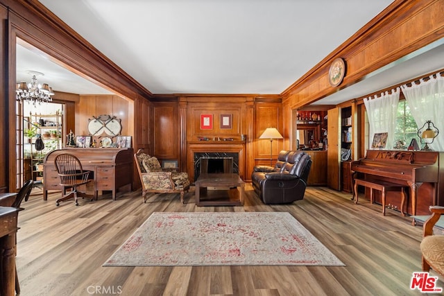 728 S Windsor Blvd, Los Angeles, CA 90005 - living room featuring a premium fireplace, ornamental molding, a chandelier, wood finished floors, and wood walls