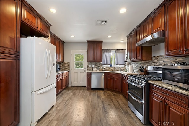 3075 Ronald, Riverside, CA 92506 - kitchen with appliances with stainless steel finishes, under cabinet range hood, a sink, tasteful backsplash, and dark wood finished floors
