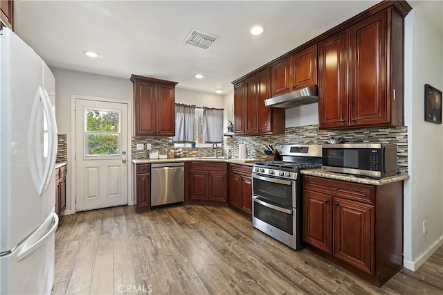 3075 Ronald, Riverside, CA 92506 - kitchen featuring appliances with stainless steel finishes, under cabinet range hood, a sink, wood finished floors, and backsplash