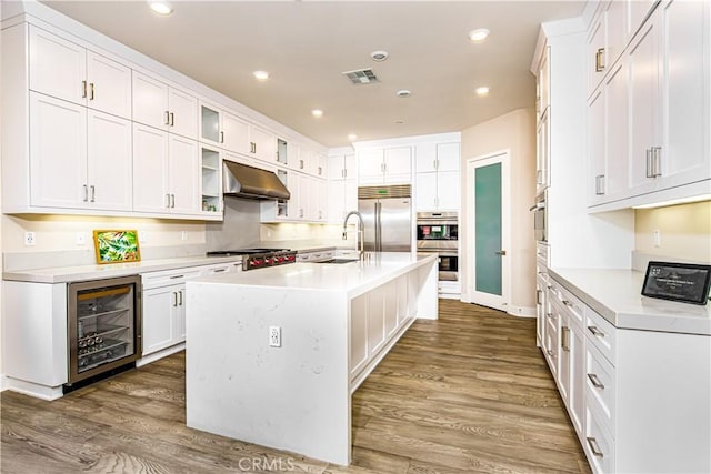 71 Einstein Way, Irvine, CA 92618 - kitchen with beverage cooler, appliances with stainless steel finishes, under cabinet range hood, light countertops, and recessed lighting