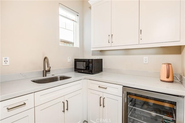 71 Einstein Way, Irvine, CA 92618 - kitchen with wine cooler, a sink, black microwave, white cabinetry, and light countertops