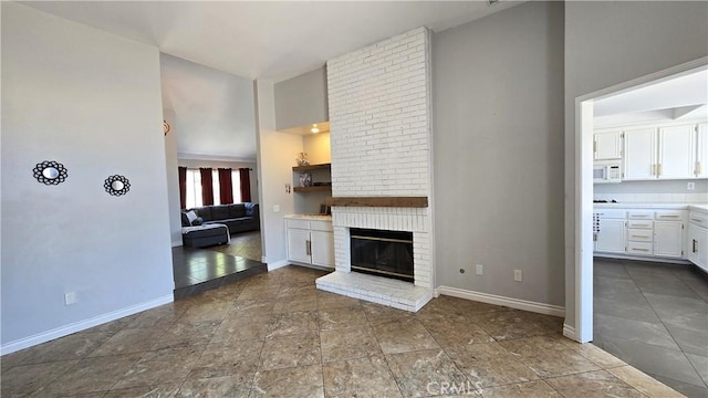 1822 Glover St, Redlands, CA 92374 - unfurnished living room with high vaulted ceiling, baseboards, and a brick fireplace