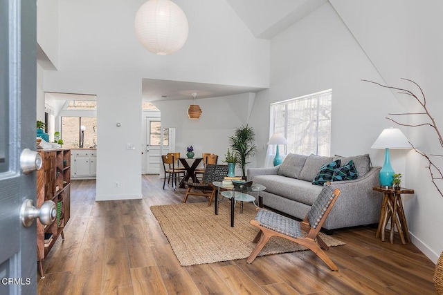 4991 Coringa Dr, Highland Park, CA 90042 - living area with a towering ceiling, healthy amount of natural light, wood finished floors, and baseboards