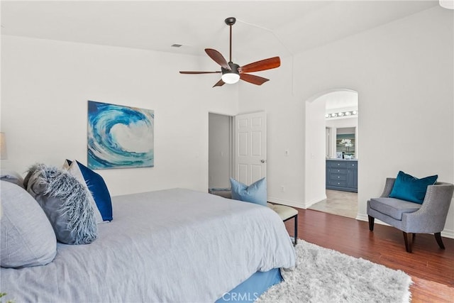 27831 Silverton Ct, Valencia, CA 91354 - bedroom with arched walkways, wood finished floors, connected bathroom, and a ceiling fan
