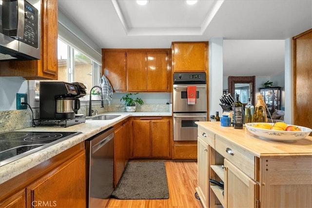 849 Shade Tree Ln, Fallbrook, CA 92028 - kitchen with appliances with stainless steel finishes, a sink, wooden counters, a tray ceiling, and light wood finished floors