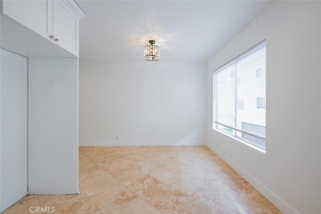 7741 Via Napoli Unit 77, Burbank, CA 91504 - empty room featuring a chandelier and baseboards