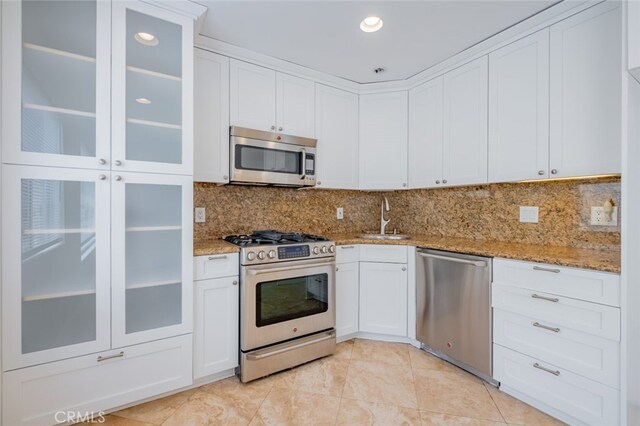 7741 Via Napoli Unit 77, Burbank, CA 91504 - kitchen featuring appliances with stainless steel finishes, light stone counters, white cabinets, and recessed lighting