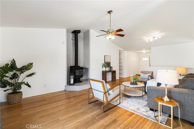 1720 N Cherry St, Chico, CA 95926 - living area with vaulted ceiling, light wood finished floors, ceiling fan, a wood stove, and built in shelves