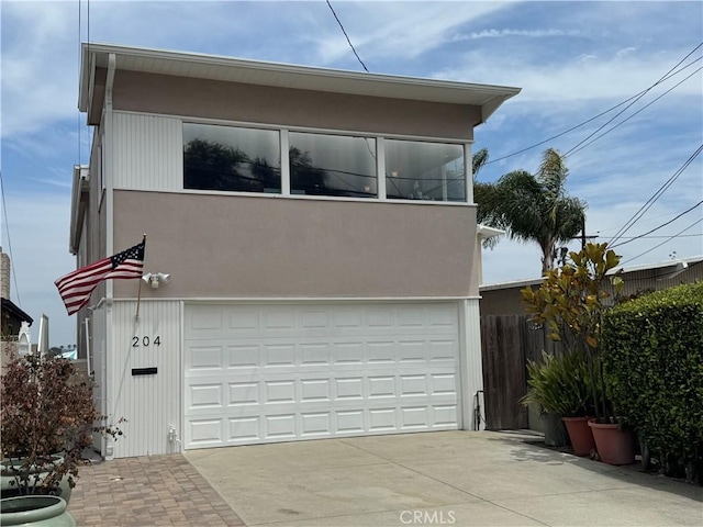 204 Larsson St, Manhattan Beach, CA 90266 - view of front facade featuring an attached garage, stucco siding, and driveway