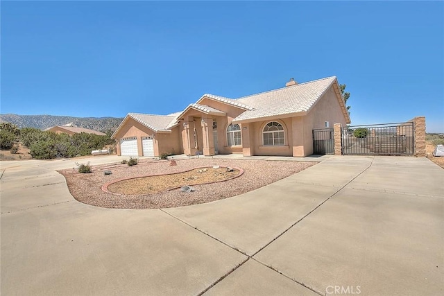 8250 Snow Cap Ave, Pinon Hills, CA 92372 - view of front of home with driveway, a gate, a chimney, an attached garage, and stucco siding