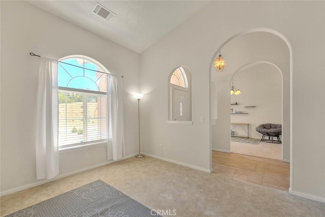 8250 Snow Cap Ave, Pinon Hills, CA 92372 - carpeted empty room featuring vaulted ceiling, arched walkways, and baseboards