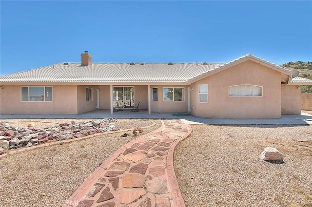 8250 Snow Cap Ave, Pinon Hills, CA 92372 - rear view of house with a tile roof, stucco siding, and a chimney