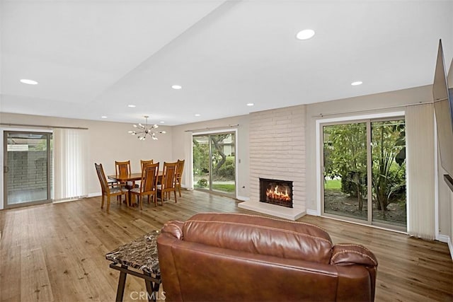 27262 Via Callejon Unit B, San Juan Capistrano, CA 92675 - living area featuring wood finished floors, a brick fireplace, recessed lighting, and a chandelier