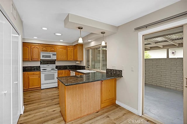 27262 Via Callejon Unit B, San Juan Capistrano, CA 92675 - kitchen featuring white appliances, a peninsula, light wood-style flooring, brown cabinets, and hanging light fixtures