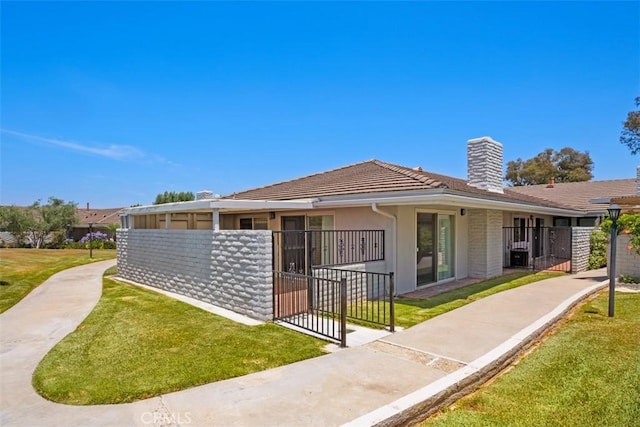 27262 Via Callejon Unit B, San Juan Capistrano, CA 92675 - rear view of house with a chimney, a gate, a tile roof, and stucco siding