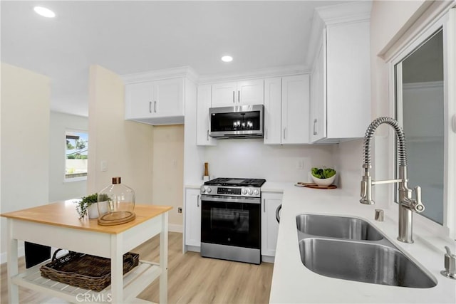 1024 E Dore St, West Covina, CA 91792 - kitchen with appliances with stainless steel finishes, a sink, light wood-type flooring, recessed lighting, and white cabinetry