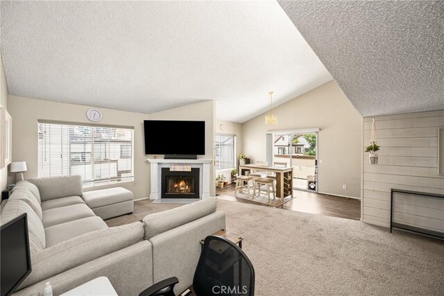 1206 S Cypress Ave Unit F, Ontario, CA 91762 - carpeted living room with a textured ceiling, a fireplace with flush hearth, lofted ceiling, and baseboards