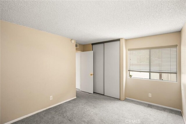1206 S Cypress Ave Unit F, Ontario, CA 91762 - unfurnished bedroom with carpet, a textured ceiling, a closet, and baseboards