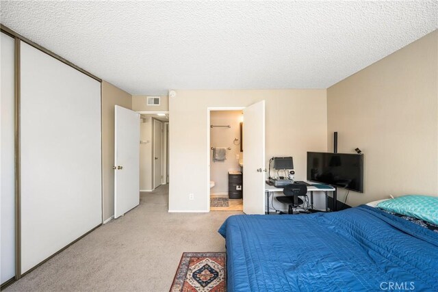 1206 S Cypress Ave Unit F, Ontario, CA 91762 - bedroom featuring light colored carpet, a textured ceiling, and ensuite bathroom