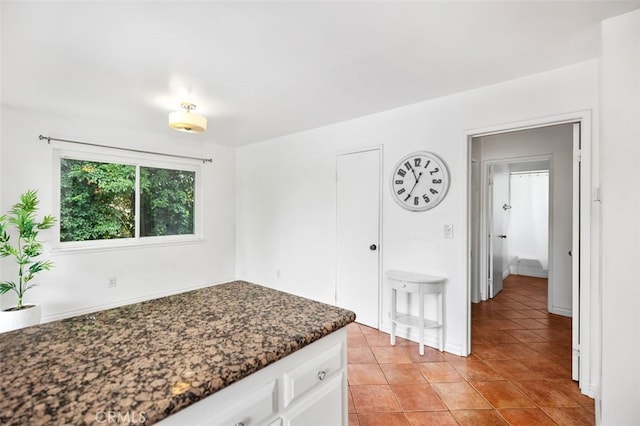 5245 Grandview Ave, Yorba Linda, CA 92886 - kitchen featuring white cabinetry, light tile patterned flooring, dark stone countertops, and baseboards