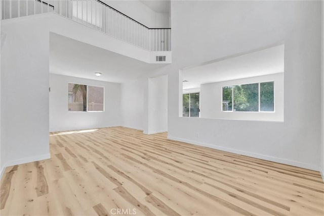 7522 Calais Ct, Rancho Cucamonga, CA 91730 - unfurnished living room featuring wood finished floors, a towering ceiling, and baseboards