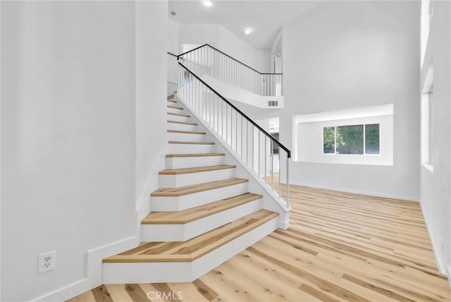 7522 Calais Ct, Rancho Cucamonga, CA 91730 - stairs with a towering ceiling, wood finished floors, and baseboards
