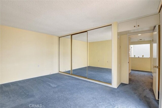 2160 Via Mariposa E Unit D, Laguna Woods, CA 92637 - unfurnished bedroom with carpet flooring, a textured ceiling, and a closet