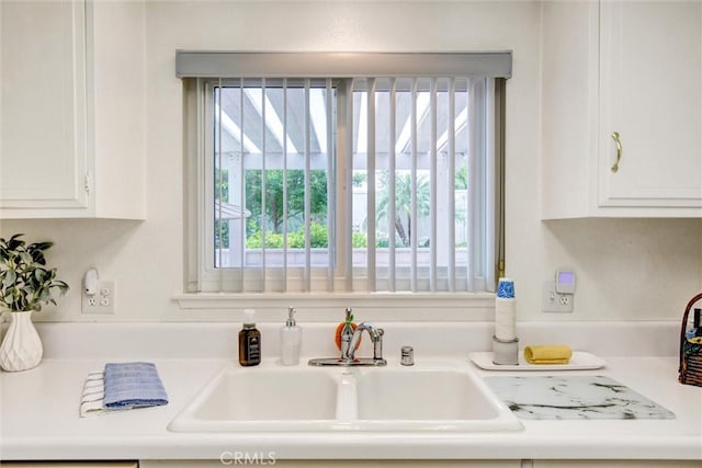2160 Via Mariposa E Unit D, Laguna Woods, CA 92637 - kitchen featuring a sink, healthy amount of natural light, and white cabinetry