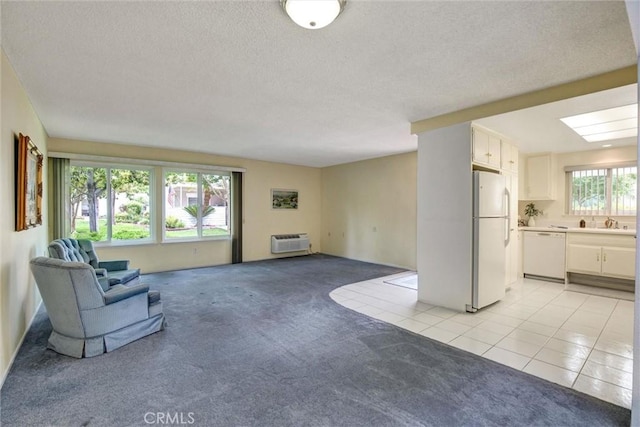 2160 Via Mariposa E Unit D, Laguna Woods, CA 92637 - unfurnished living room featuring light colored carpet, a wall unit AC, a textured ceiling, light tile patterned floors, and a sink