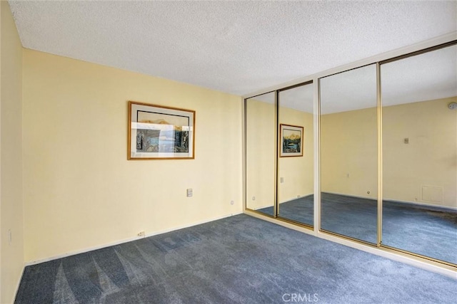 2160 Via Mariposa E Unit D, Laguna Woods, CA 92637 - unfurnished bedroom featuring dark colored carpet, multiple closets, and a textured ceiling