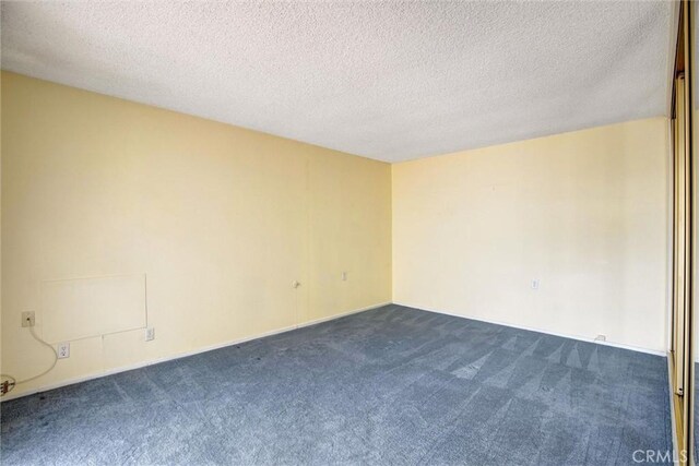 2160 Via Mariposa E Unit D, Laguna Woods, CA 92637 - empty room with dark colored carpet and a textured ceiling