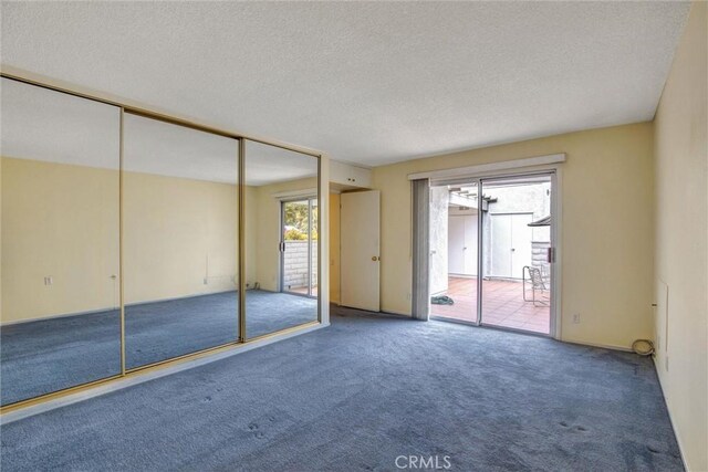 2160 Via Mariposa E Unit D, Laguna Woods, CA 92637 - unfurnished bedroom featuring carpet flooring, access to outside, multiple windows, a textured ceiling, and a closet