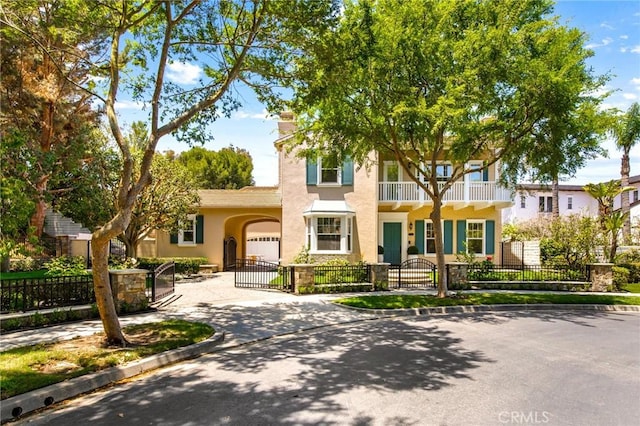3 Seabluff, Newport Beach, CA 92660 - view of front of property featuring concrete driveway, a fenced front yard, a gate, stucco siding, and a balcony