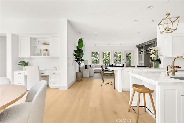 3 Seabluff, Newport Beach, CA 92660 - kitchen with a peninsula, open shelves, a breakfast bar area, white cabinetry, and recessed lighting