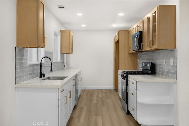 9737 Felipe Ave, Montclair, CA 91763 - kitchen with stainless steel appliances, light countertops, light wood-type flooring, glass insert cabinets, and tasteful backsplash