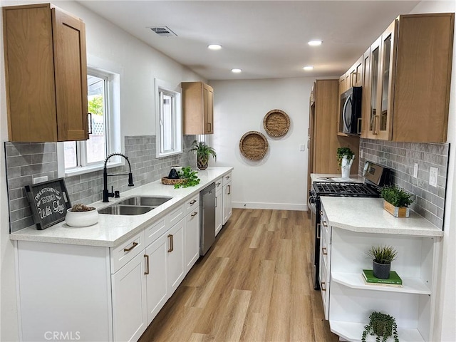 9737 Felipe Ave, Montclair, CA 91763 - kitchen with stainless steel appliances, open shelves, tasteful backsplash, light wood-style floors, and recessed lighting