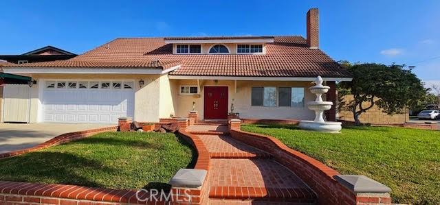9715 Raven Cir, Fountain Valley, CA 92708 - view of front of property with a tile roof, a chimney, a garage, concrete driveway, and stucco siding