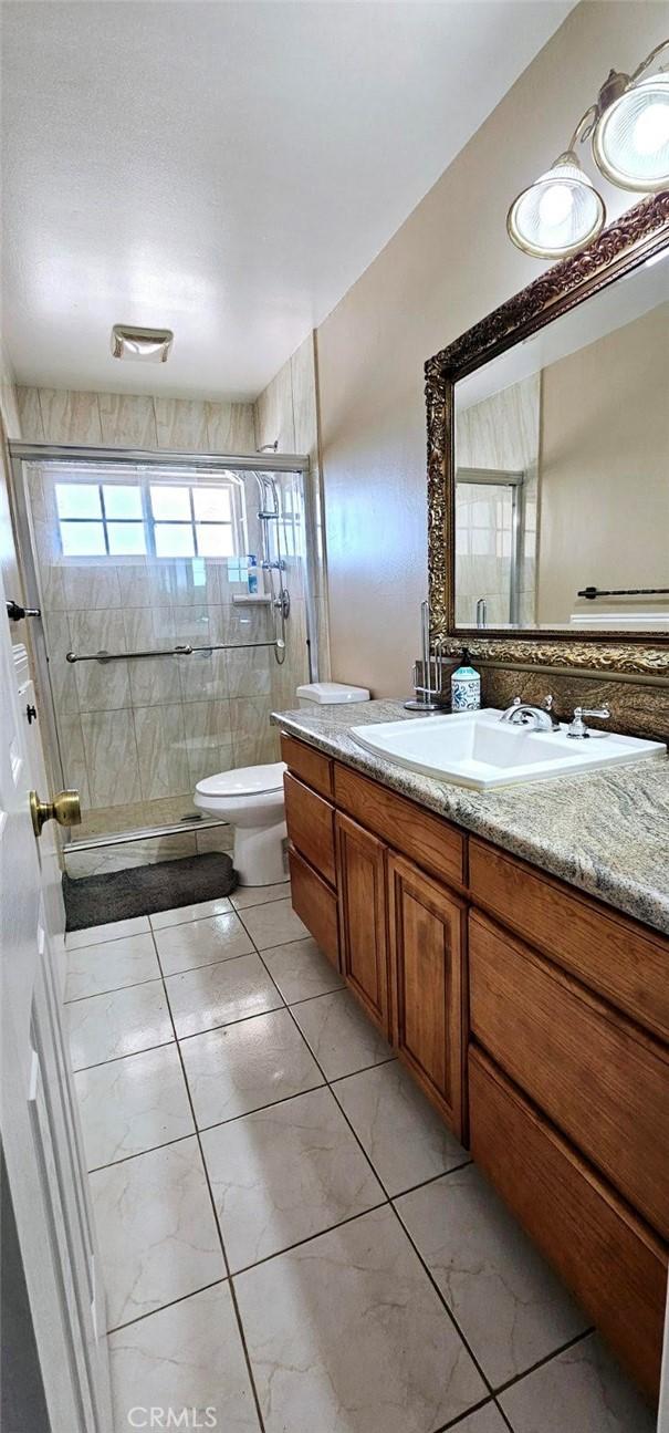 9715 Raven Cir, Fountain Valley, CA 92708 - bathroom featuring vanity, toilet, and a stall shower