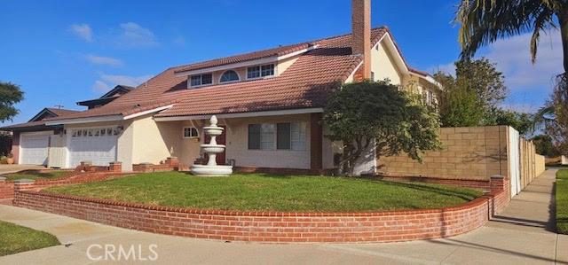 9715 Raven Cir, Fountain Valley, CA 92708 - mediterranean / spanish house with a garage, driveway, a front lawn, a tile roof, and stucco siding