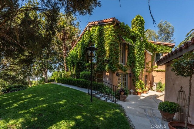 3492 Circle Rd, San Bernardino, CA 92405 - view of home's exterior with a yard, stucco siding, and a tile roof