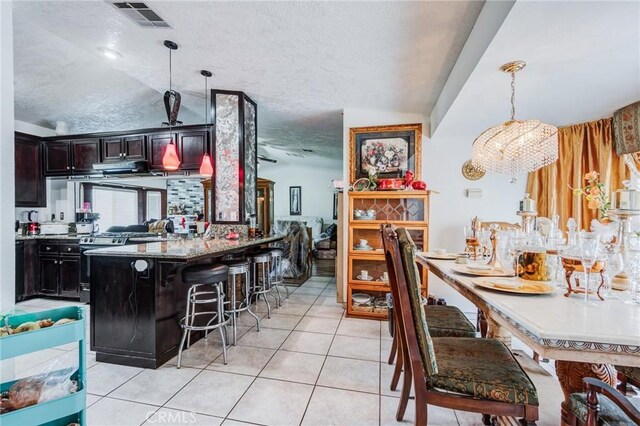 15799 Cromdale St, Hesperia, CA 92345 - kitchen featuring a kitchen breakfast bar, pendant lighting, light tile patterned flooring, a textured ceiling, and a peninsula