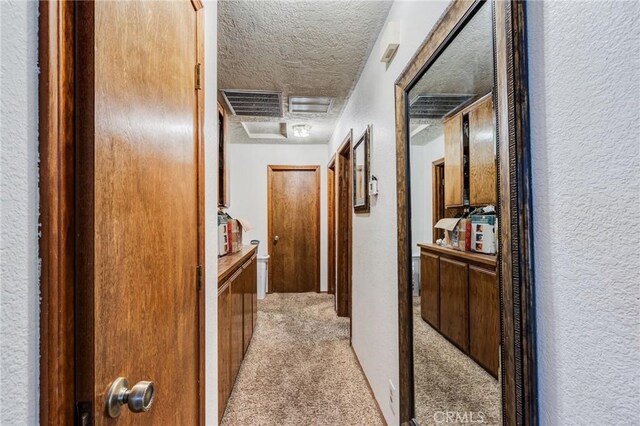 15799 Cromdale St, Hesperia, CA 92345 - hall with a textured wall, a textured ceiling, attic access, and light colored carpet