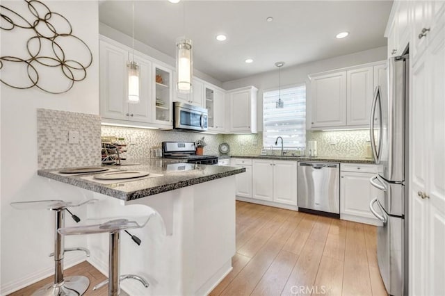 6038 Grace St, Chino, CA 91710 - kitchen featuring appliances with stainless steel finishes, a peninsula, white cabinets, pendant lighting, and recessed lighting