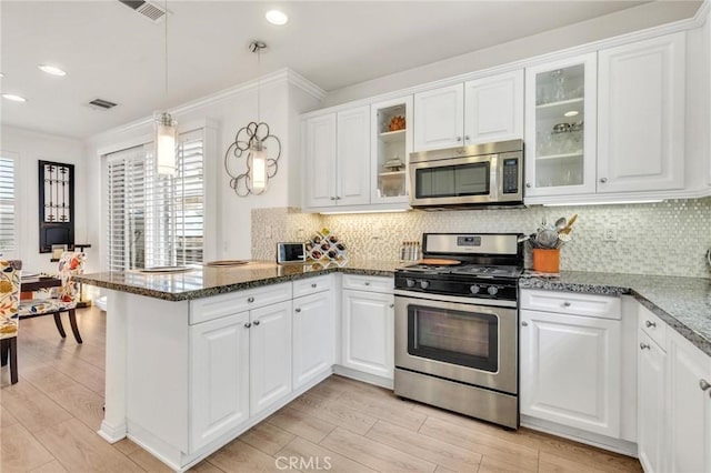 6038 Grace St, Chino, CA 91710 - kitchen with appliances with stainless steel finishes, a peninsula, white cabinetry, light wood-type flooring, and decorative light fixtures