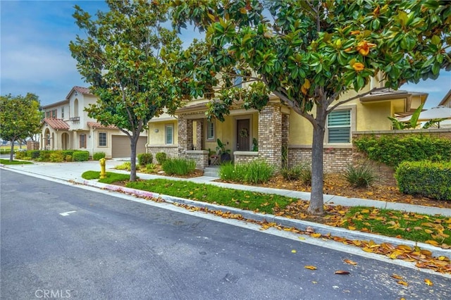 6038 Grace St, Chino, CA 91710 - view of front of property with stucco siding, concrete driveway, a garage, and brick siding